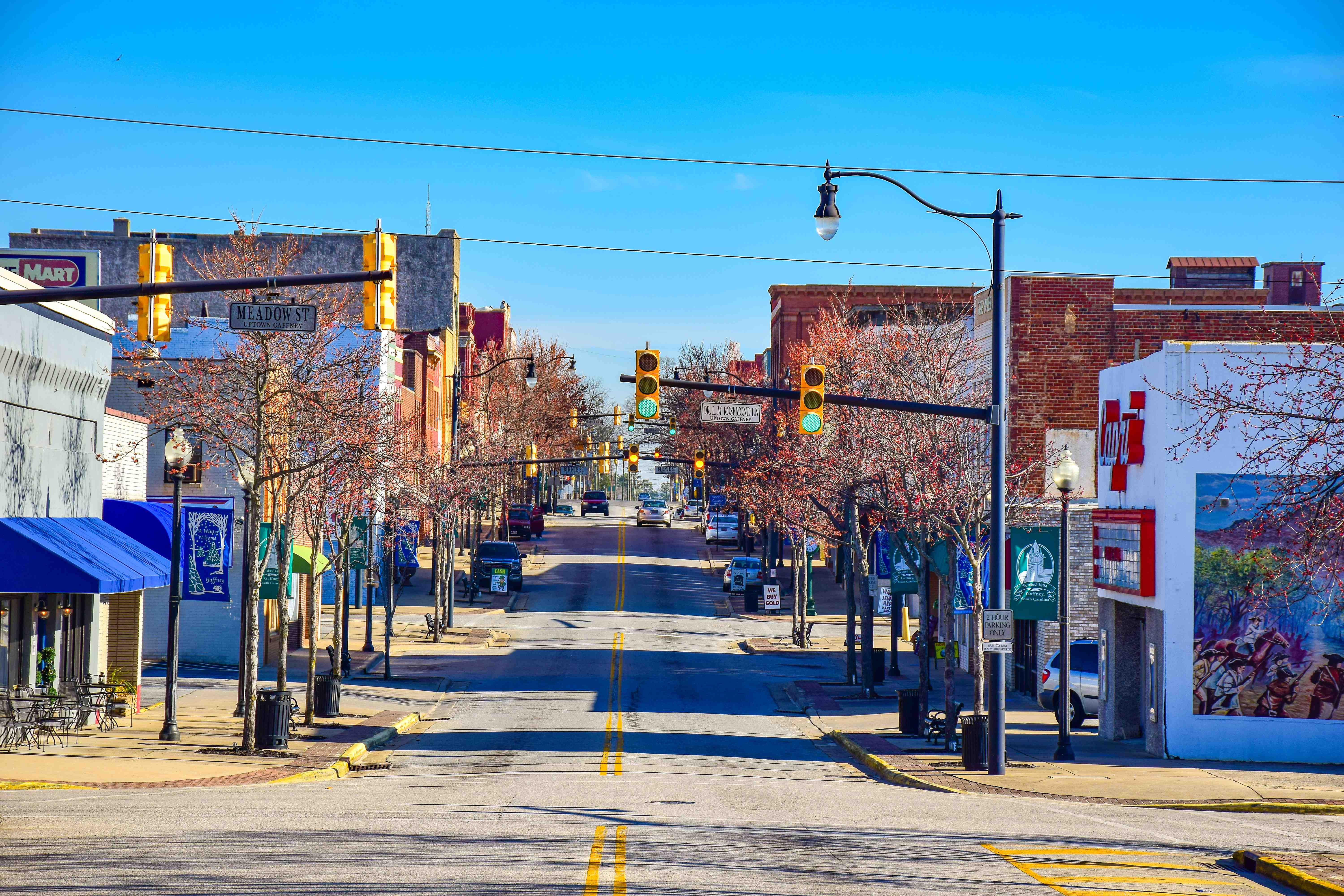A view of a main street with stores and traffic lights.