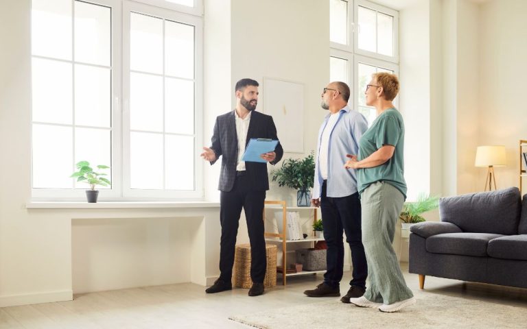 Stock image of a real estate agent showing a couple a home.